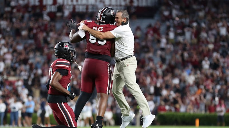 South Carolina head coach Shane Beamer celebrates a fumble recovery with defensive tackle...